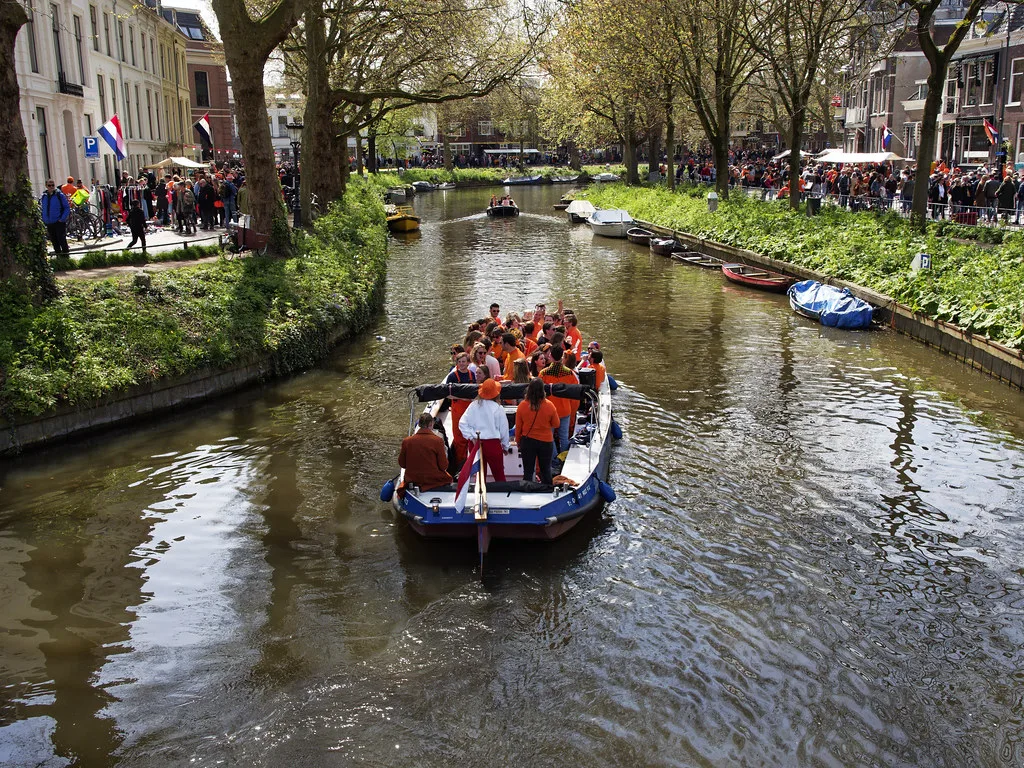 A boat party on a canal on King's Day.