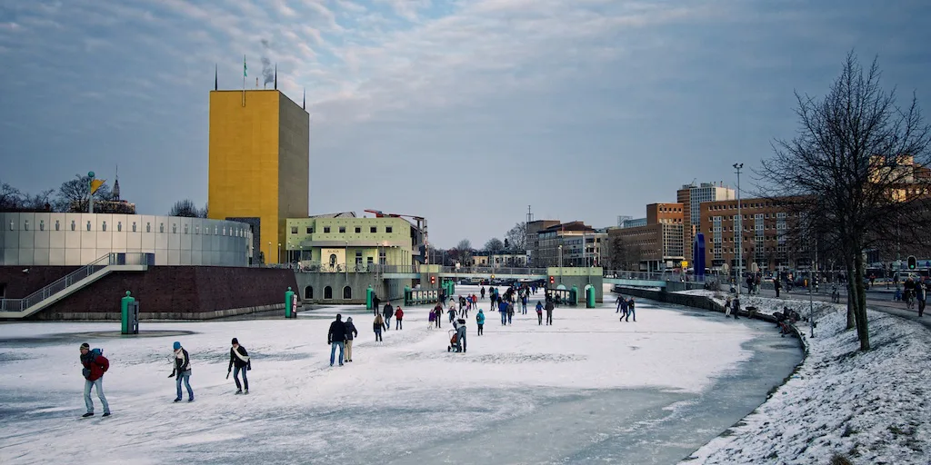 Skaters on the frozen canal by the Groninger Museum, Groningen.